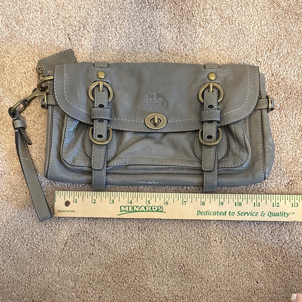 100% Authentic Coach Gray Leather Clutch with Bronze Buckle Design.